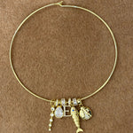Thin gold cuff necklace stacked with CZ slider charms and pendant charms