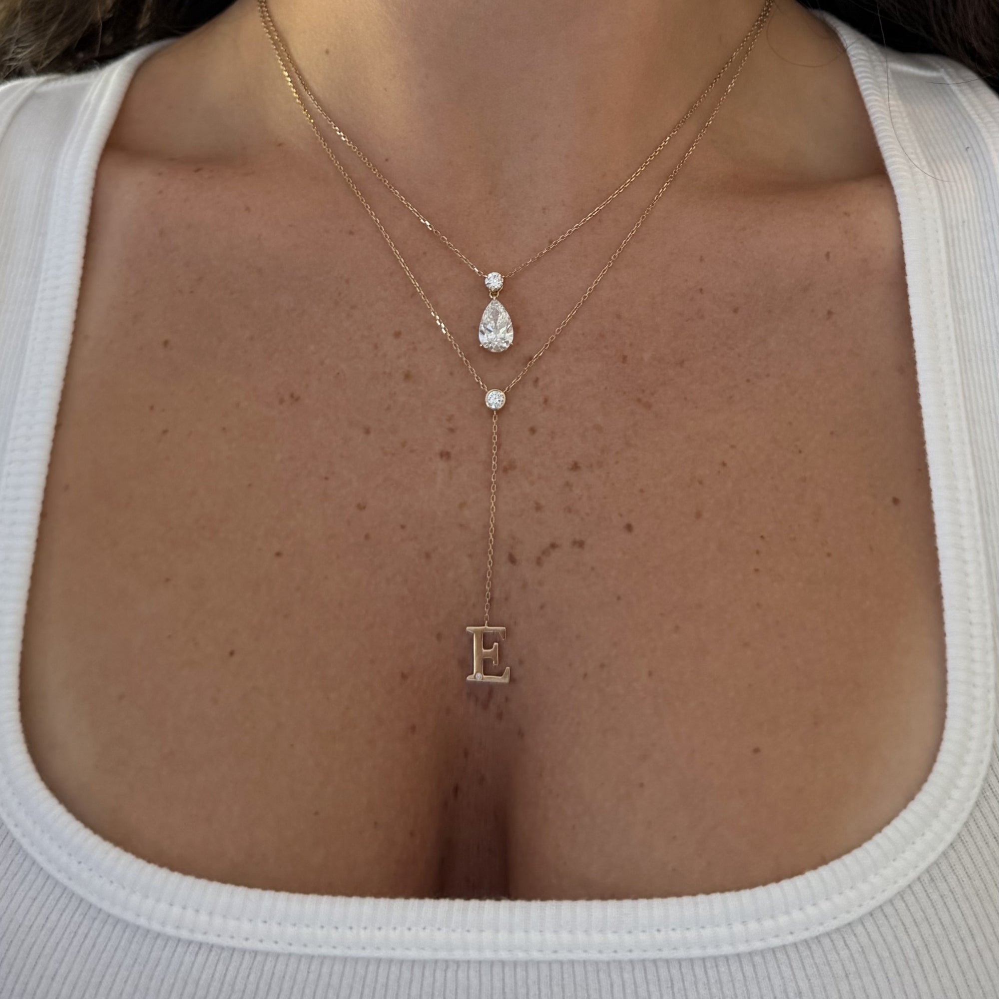 Timeless Lariat Letter Necklace with an E initial layered with a pear diamond necklace