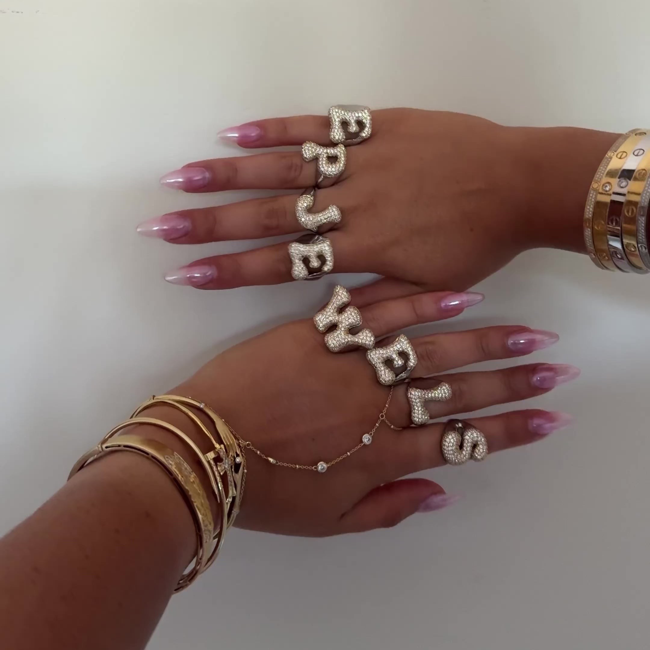 Video of Iced Jumbo Letter Rings spelling EP JEWELS across the fingers