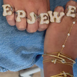 Video of hands in Iced Jumbo Letter Rings spelling EP JEWELS over denim