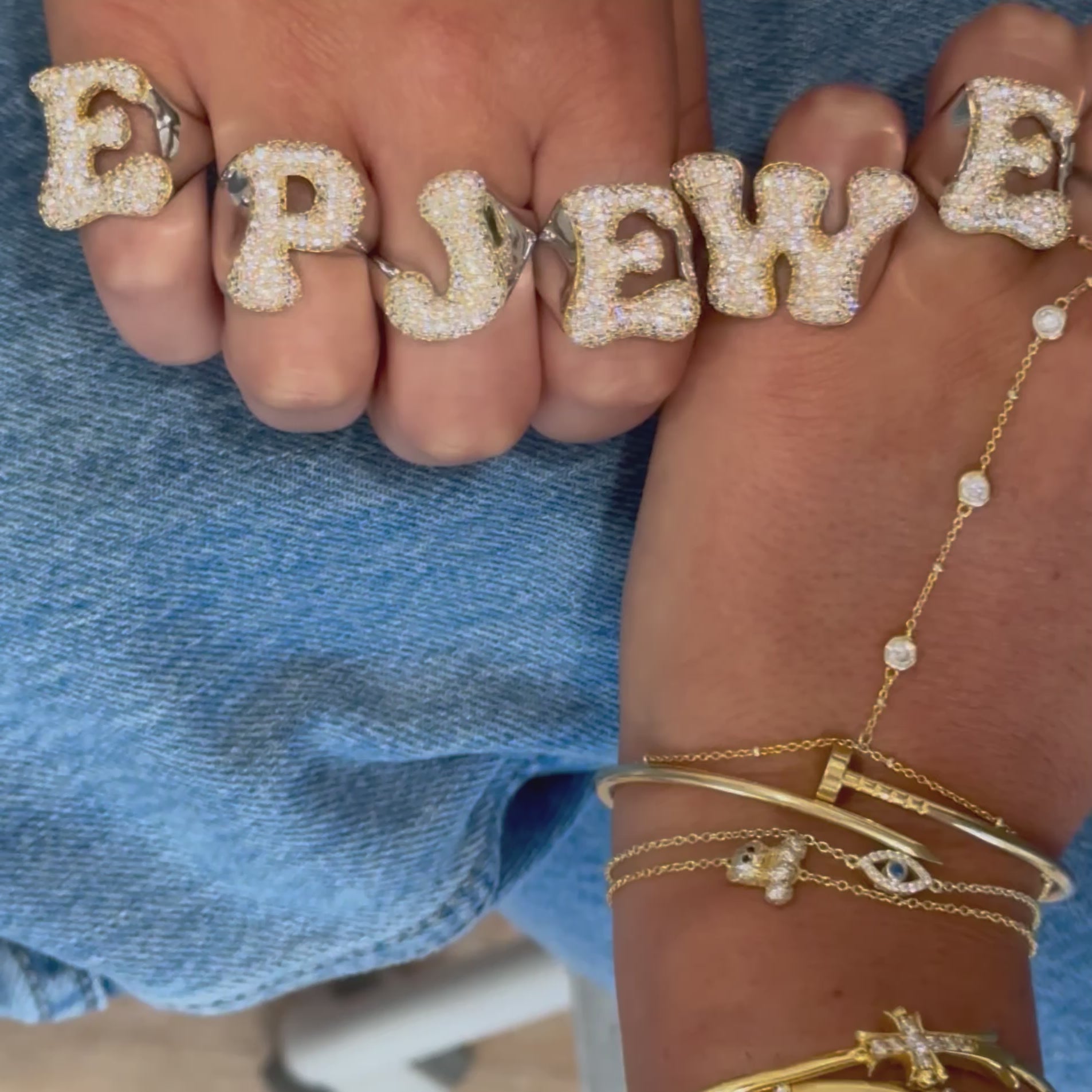 Video of hands wearing Iced Jumbo Letter Rings that spell EP JEWELS